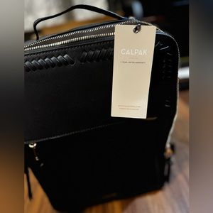 Brand new black calpak never used!!! Minor marks on carry on bag from storage